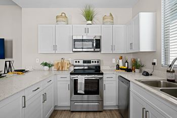 A large white kitchen with stainless steel appliances and white cabinets